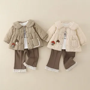 Detail of baby quilted jacket and pants set with mushroom embroidery and lace trim