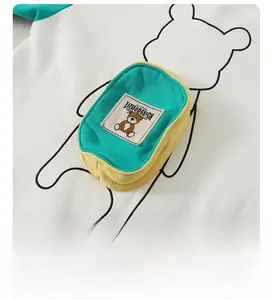 Close-up of cotton baby jumpsuit back featuring 3D mini backpack and bear patch