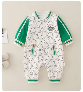 Detail of baby cotton romper with green sleeves, bear print, and snap button closure