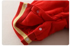 Dettagli della tutina rossa neonato con bordi a costine a righe e bottoni a pressione