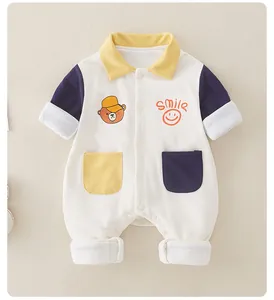 Close-up of baby romper with yellow collar, smile print, and bear cartoon hood