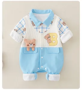 Detail of baby romper with blue collar, teddy bear patch and snap button closure
