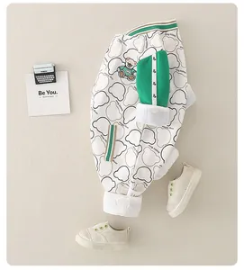 Close-up of baby pants with bear prints and green patchwork details on soft cotton fabric
