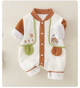Close-up of cotton waffle fabric on baby romper with bear embroidery and brown trim