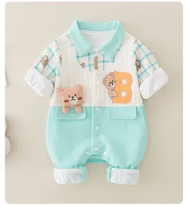 Detail of baby romper featuring mint green stitching, letter B patch and cute 3D bear