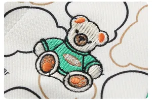 Detailed view of baby romper featuring a cute bear embroidery with NICE text and clouds