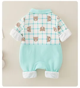 Detail of mint green baby romper showing brown bear print and plaid pattern texture