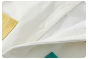 Detail of snap button closure and yellow pocket on soft cotton baby romper outfit