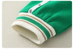 Close-up of green baby jumpsuit ribbed cuff with brown stripes and RK logo tape detail
