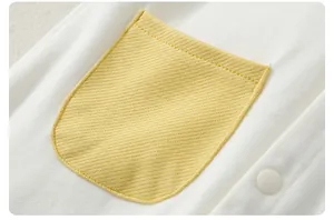 Close-up of baby romper showing yellow waffle knit pocket and white button detail
