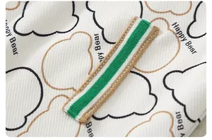 Close-up of knit fabric with cartoon bear prints and decorative tricolor stripe tape