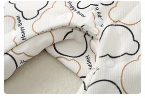 Detail of quilted baby romper fabric with Happy Bear print and white snap buttons