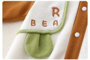 Detail of baby romper featuring waffle knit texture and BEAR letter embroidery