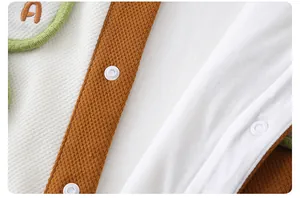 Macro detail of baby romper showing brown waffle knit texture and soft white inner lining