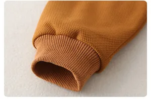 Detailed macro view of ginger yellow knit cotton sleeve with ribbed cuff for baby romper