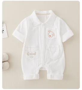 Detail eines weißen Baby-Stramplers aus Baumwolle mit Welpenstickerei und Taschen