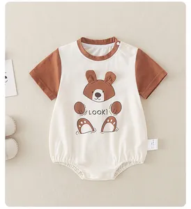 Detail of baby cotton onesie featuring cartoon bear print with 3D ears and snap buttons