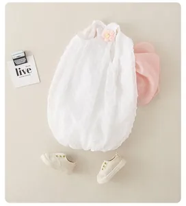 Detalle de mameluco blanco con lunares para bebé con flor rosa 3D y textura suave