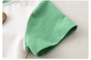 Detailed close-up of baby bodysuit cuffs showing green and white contrast stitching