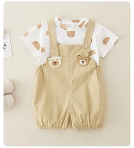 Détail de l'ensemble bébé en coton avec t-shirt imprimé ours et salopette kaki