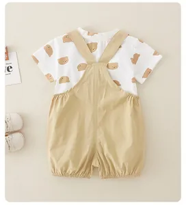 Détail d'un ensemble d'été pour bébé avec t-shirt ours et short à bretelles kaki