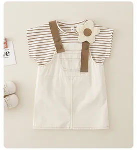 Detalle de conjunto para bebé niña en algodón con camiseta a rayas y vestido beige