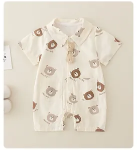 Detail of baby cotton romper with cartoon bear print, bow tie and front pockets