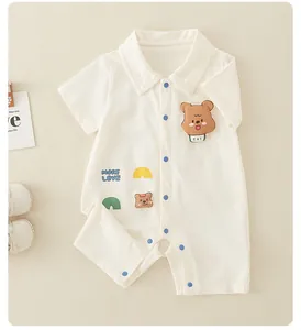 Detailansicht eines Baby-Stramplers mit Bären-Patches, blauen Knöpfen und Reverskragen