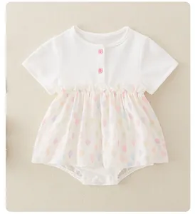 Detail of baby cotton bodysuit featuring pink buttons and colorful balloon pattern