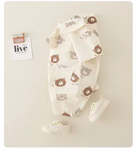 Flat lay of baby cotton romper with bear prints and matching white canvas sneakers