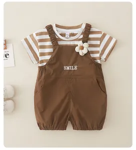 Detalle de conjunto de algodón para bebé con camiseta a rayas y peto con bordado sonrisa