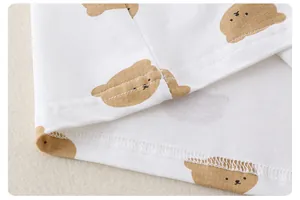Détail d'un t-shirt en coton pour bébé avec imprimé ours et coutures à double aiguille