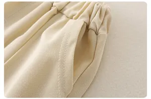 Detalle de pantalones cortos de algodón con cintura elástica y tela crema texturizada