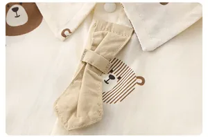 Detail of baby cotton onesie with cartoon bear print and soft decorative bowtie
