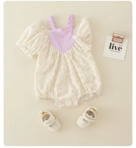 Detailed flat lay of floral baby romper with lilac trim and soft white sneakers