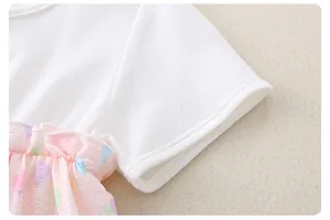 Detail of baby cotton bodysuit featuring white knit fabric and pink balloon print ruffles
