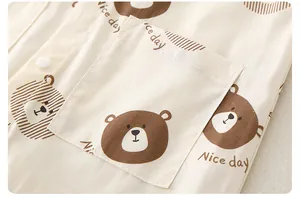 Close-up of a baby romper cotton pocket with cartoon bear print and 'Nice day' text