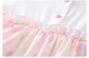 Detail of baby bodysuit with pink buttons, ruffled waist, and colorful balloon patterns