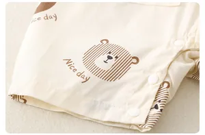 Detail of soft cotton baby romper fabric with cute bear print and secure snap buttons