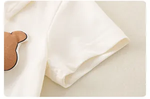 Detailaufnahme von Piqué-Baumwolle und Bären-Aufnäher am Baby-Kurzarm-Strampler
