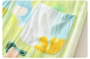 Detail of artistic graffiti print and square pocket on lightweight cotton baby romper