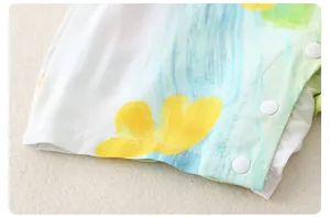 Close-up of cotton baby romper featuring watercolor floral print and white resin snaps