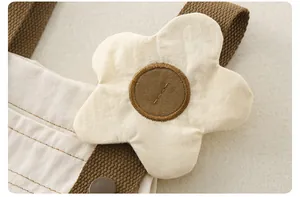 Detalle de costura de tirantes y aplicación de flores en el vestido de algodón infantil