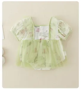 Detail van een gebloemde babyromper met groene mesh tutu en pofmouwen in platte weergave