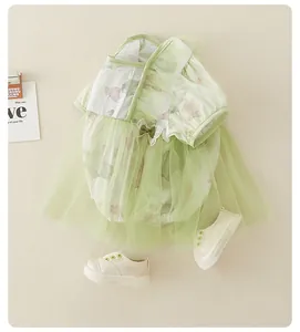 Babyromper met bloemenprint, groene tule rok en witte canvas schoentjes in platte lay