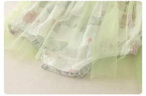 Detail van babyrompertje met bloemenprint, groene tule tutu en drukknoopjes aan de onderkant