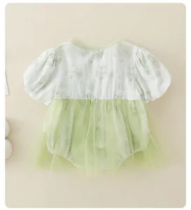 Dettaglio pagliaccetto floreale neonata con gonna in tulle verde e maniche a sbuffo