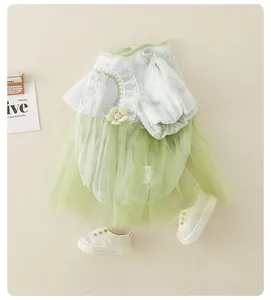Dettaglio tutina a fiori per neonata con gonna in tulle verde e fiore giallo