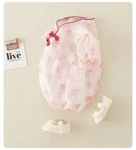 Flat lay of pink floral mesh baby romper dress with traditional Chinese frog buttons