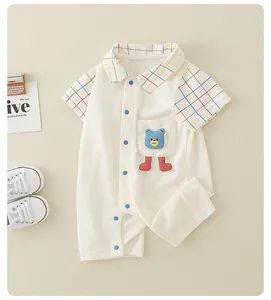 Detail of baby cotton romper with colorful plaid collar and cute bear patch decoration